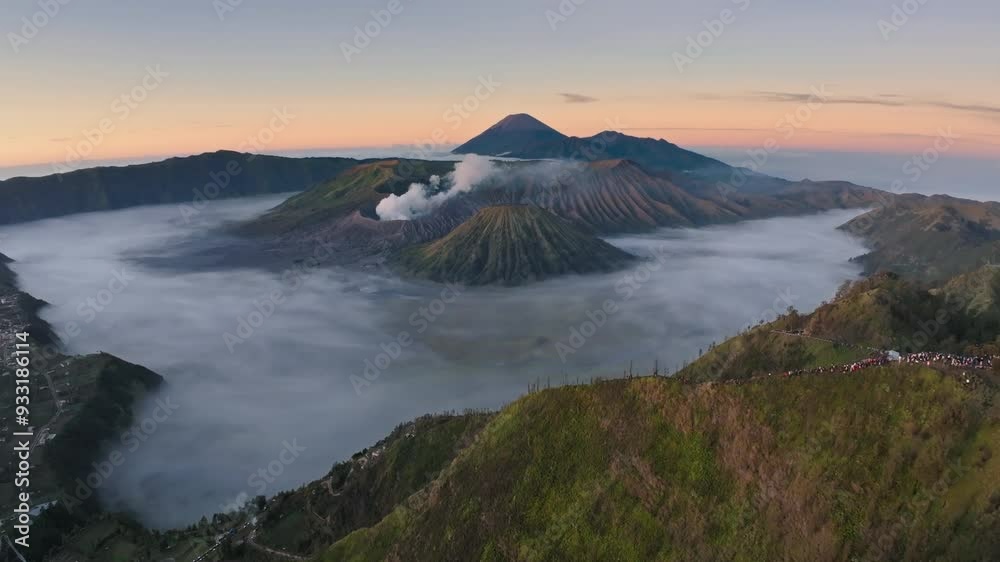 Aerial drone fly pass hill to reveal Bromo volcano, Java, Indonesia
