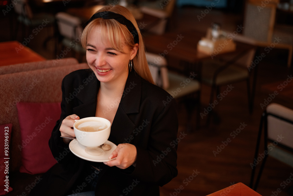 Happy blond businesswoman holding coffee cup sitting at cafe Happy blond businesswoman holding coffee cup sitting at cafe