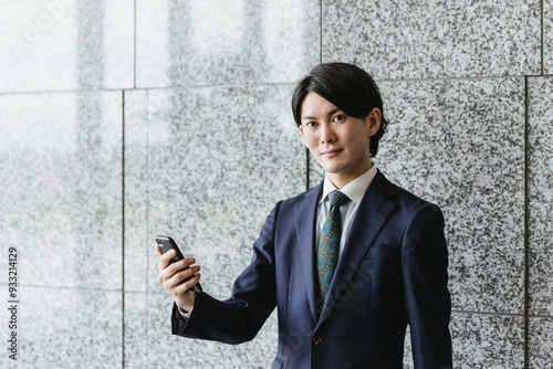 スマートフォンを持つ若い男性・IoTとビジネスのイメージ photo