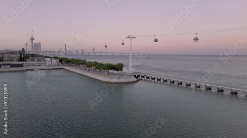 Establishing Aerial Shot of Park of Nations district in Lisbon with Tagus River and Vasco da Gama Bridge at sunset photo