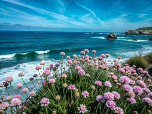 Vibrant sea thrift and resilient wildflowers sway gently in the ocean breeze amidst a lush, emerald-green coastal meadow with tranquil waves crashing in the distance. photo