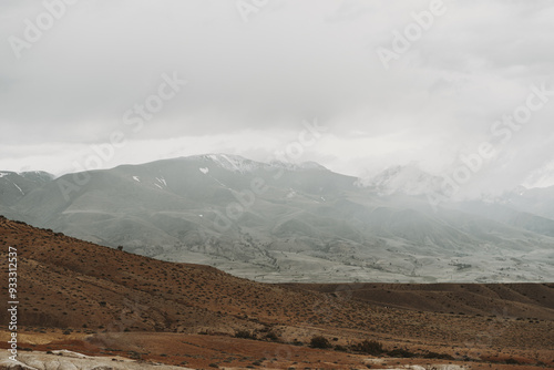 Mist shrouds the Altai Mountains as autumn arrives, highlighting the serene and rugged landscape in a captivating display of nature's beauty photo