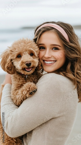 Girl embraces her fluffy dog on the beach at sunset