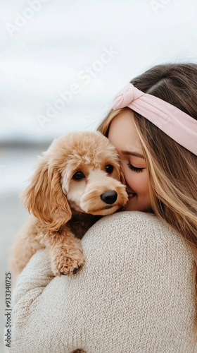 Girl embraces her fluffy dog on the beach at sunset