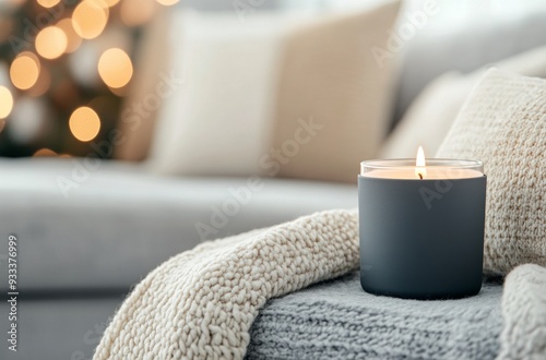 Cozy living room setting with lit candles and soft blankets during festive se...