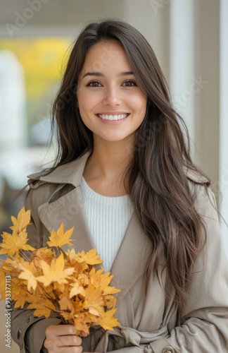 Smiling woman holding yellow leaves in a colorful autumn setting