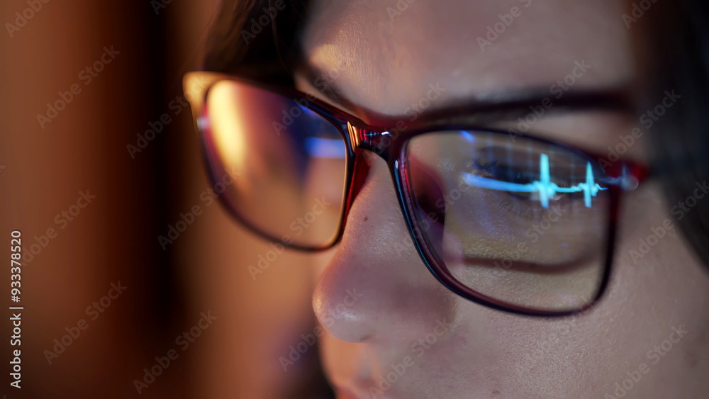 Close-up of a developer wearing glasses, coding on a computer. Code and analytics reflections in the glasses emphasize focus on cybersecurity and software development. Close-up of a developer wearing glasses, coding on a computer. Code and analytics reflections in the glasses emphasize focus on cybersecurity and software development.