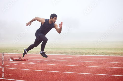 Fototapeta Naklejka Na Ścianę i Meble -  Outdoor, exercise and man running at track for fitness, sports and training for competition. Mist, fog and Asian male athlete with speed at athletics field for cardio, workout and practice for race