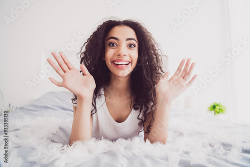 Photo of young attractive woman excited raise hands lying bed feathers wear stylish pajama soft comfy bedroom white room interior inside