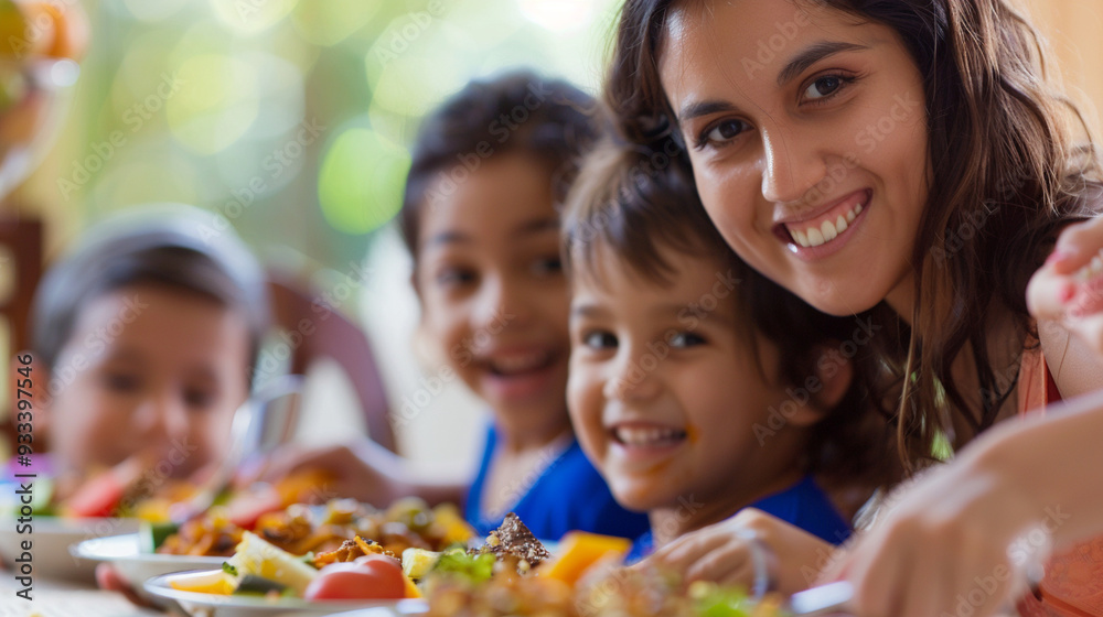 Close-up of a mother serving dinner to her children, with their excited faces in the background Close-up of a mother serving dinner to her children, with their excited faces in the background
