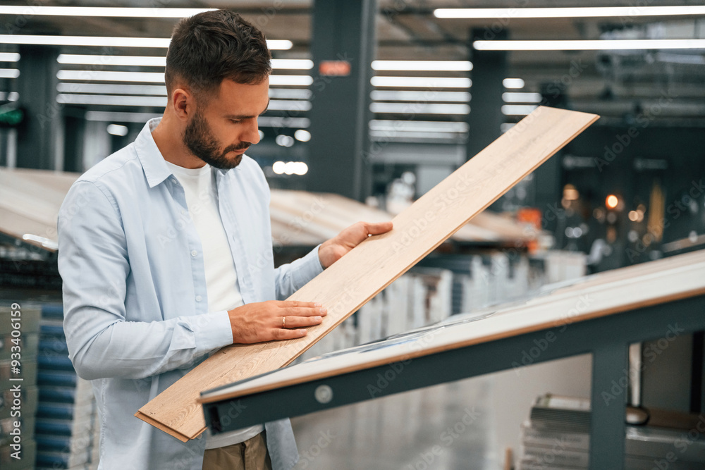 Parquet, choosing. Man is in the hardware shop Parquet, choosing. Man is in the hardware shop