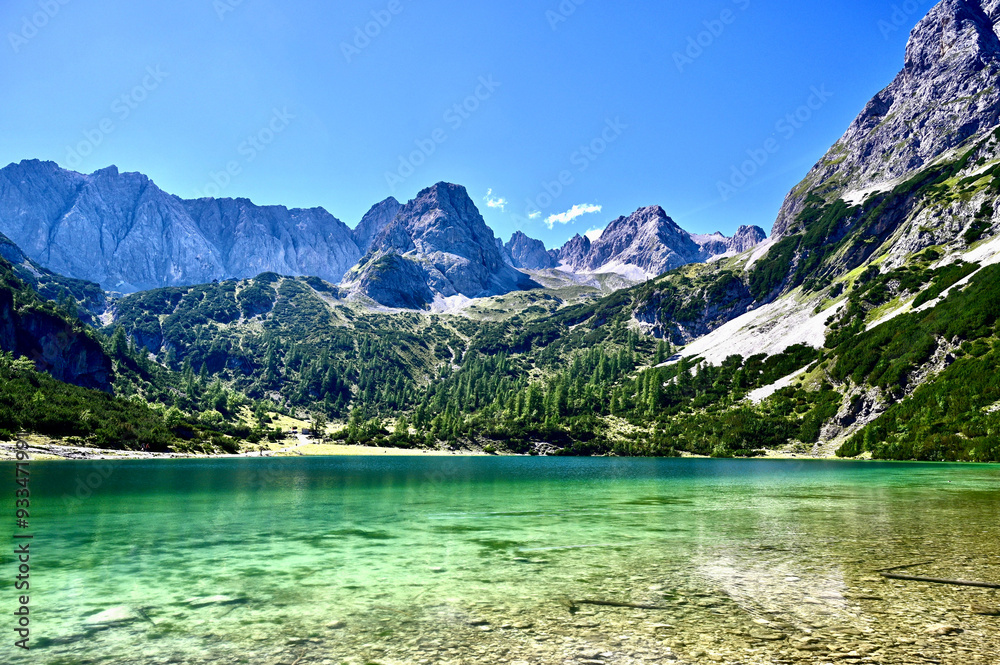 A breathtaking alpine landscape featuring a crystal-clear emerald lake A breathtaking alpine landscape featuring a crystal-clear emerald lake