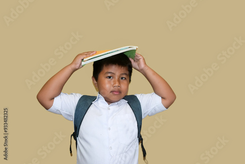 adorable asian fat boy smiling happily wearing indonesian student uniform isolated on brown background, Portrait of little boy elementary school, Back to school. Ready go to school