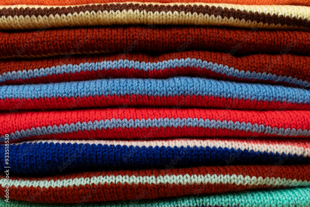 Multicolored hand-knit sweaters, close up. Multicolored hand-knit sweaters, close up.