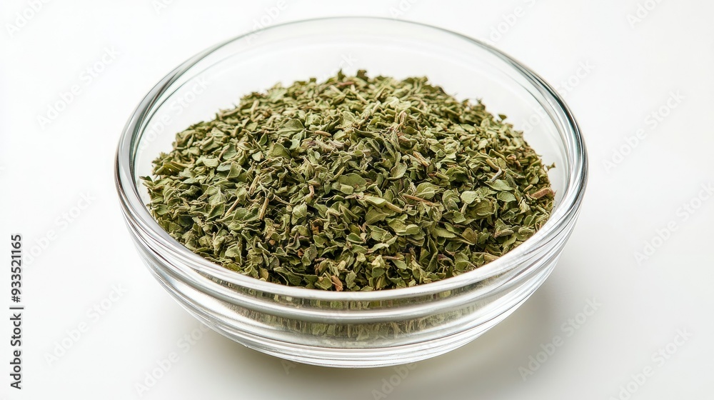A round glass bowl filled with dried oregano, isolated on a clean white surface, with the herb's details clearly visible through the transparent bowl. A round glass bowl filled with dried oregano, isolated on a clean white surface, with the herb's details clearly visible through the transparent bowl.