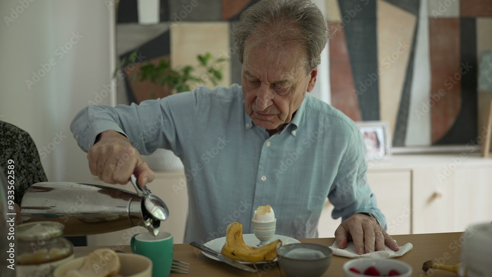Elderly man pouring coffee during breakfast, sitting at a dining table with an egg and banana, in a cozy home setting, capturing a peaceful morning routine and the simplicity of daily life Elderly man pouring coffee during breakfast, sitting at a dining table with an egg and banana, in a cozy home setting, capturing a peaceful morning routine and the simplicity of daily life