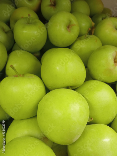 Green apples in the supermarket. There are a lot of green apples on the market. The concept is the benefits of green apples. Apple background. Organic fruits. Vegetarianism.