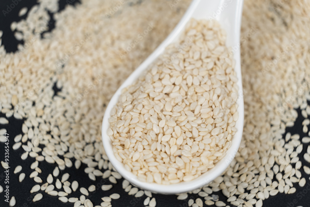 White roasted sesame seeds in a spoon White roasted sesame seeds in a spoon