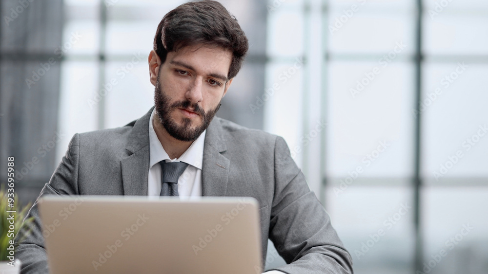 Successful businessman working inside office, man in business suit working at workplace with documents and laptop Successful businessman working inside office, man in business suit working at workplace with documents and laptop