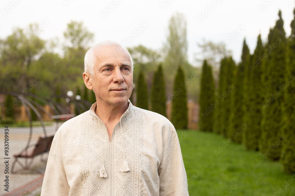Senior man with gray hair in nature wearing Ukrainian embroidered shirt. Independence day of Ukraine