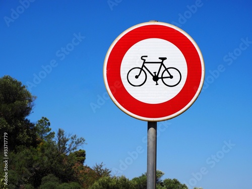 A red circle with a bicycle symbol inside outdoors, indicating that bicycles are prohibited from entering or using the area