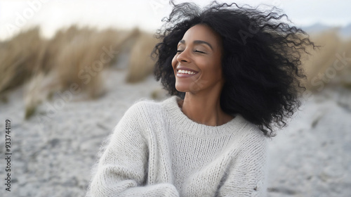 Middle age African-American woman with wind swept hair on the beach, relaxing vacation, copy space