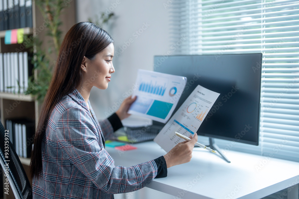 Asian businesswoman working with financial graphs at the office Asian businesswoman working with financial graphs at the office