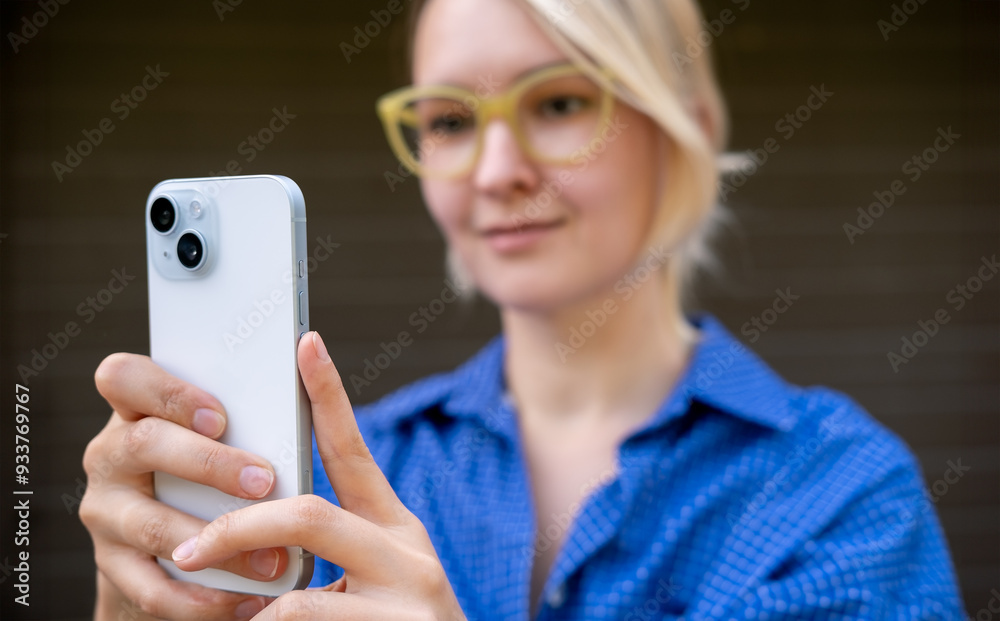 Young blond woman is taking a picture of herself, making selfie. Also she is having a video call with friends, chatting and talking. Young blond woman is taking a picture of herself, making selfie. Also she is having a video call with friends, chatting and talking.