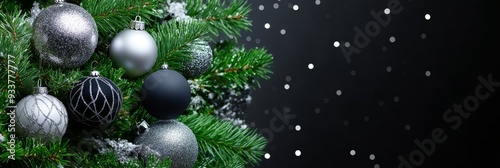 Elegant Silver and Black Christmas Tree Ornaments with Snowfall - A close-up of a Christmas tree adorned with silver and black ornaments, with a snowy background, symbolizing elegance, festivity, wint photo