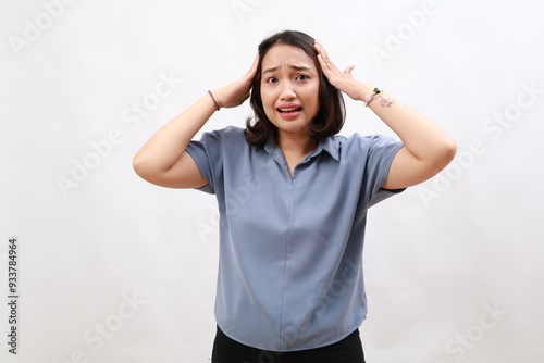 Portrait of shocked anxious asian woman in panic, holding hands on head and worrying, standing frustrated and scared against white background photo