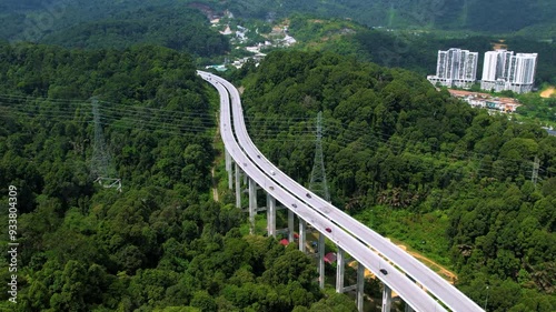 Aerial view of the Tree Giam Kanching bypass highway winding through the mountains of Rawang, Selangor, Malaysia surrounded by greenery.