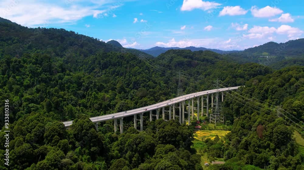 Aerial view of the Tree Giam Kanching bypass highway winding through the mountains of Rawang, Selangor, Malaysia surrounded by greenery.
