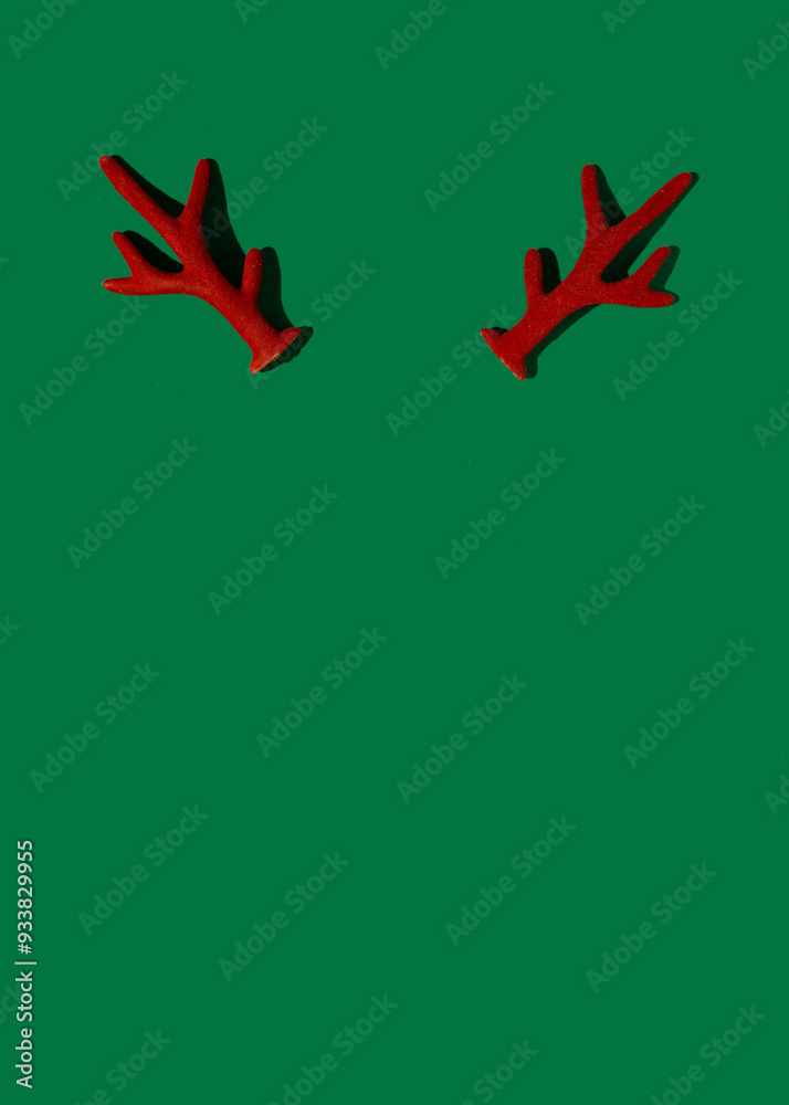 Red reindeer antlers on a moss green background, minimalist winter holidays composition, Christmas concept. Red reindeer antlers on a moss green background, minimalist winter holidays composition, Christmas concept.