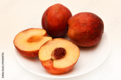 Ripe peaches on a white plate. Juicy fruits.