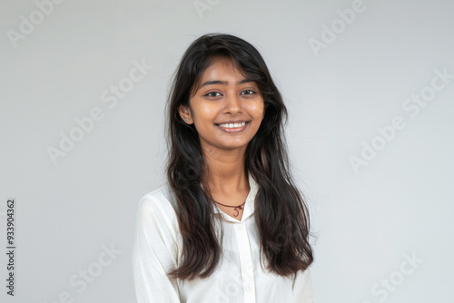 A charming Asian woman dressed in elegant white office attire, with a simple and clean design, stands confidently with a professional hairstyle and subtle makeup against a neutral background.