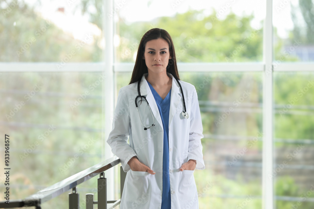 Beautiful nurse with stethoscope near railings in hospital Beautiful nurse with stethoscope near railings in hospital