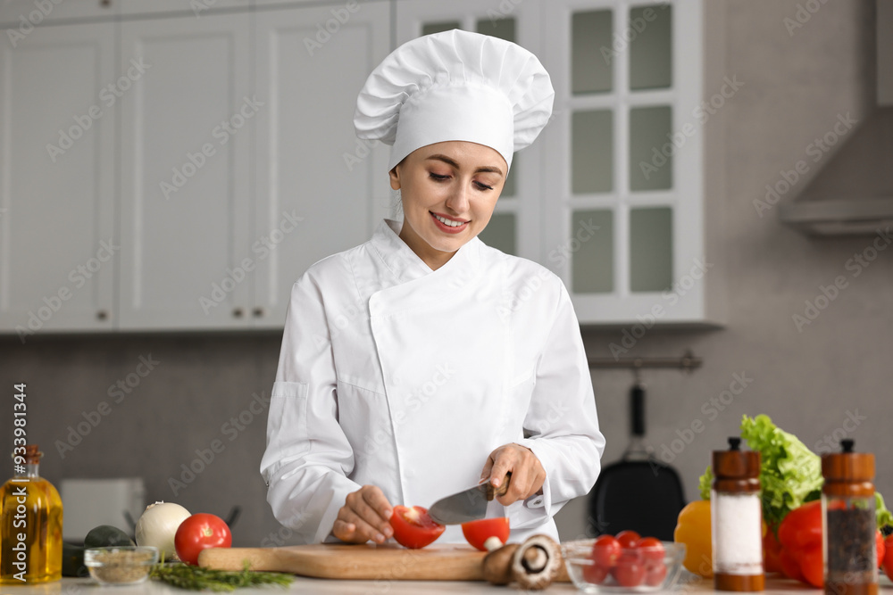 Professional chef cutting tomato at table in kitchen Professional chef cutting tomato at table in kitchen