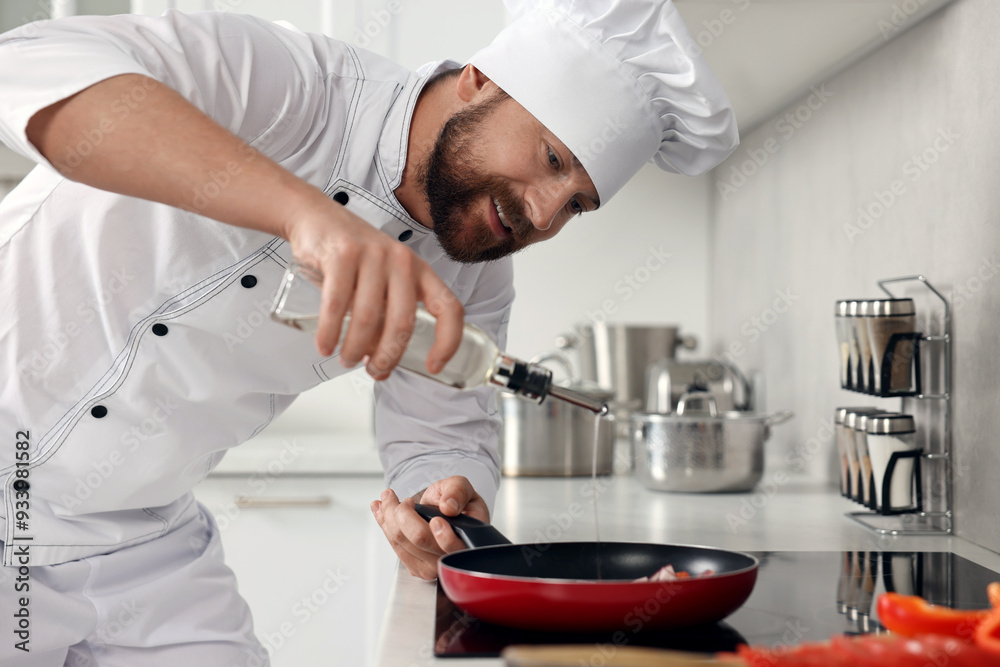 Professional chef pouring oil into frying pan in kitchen