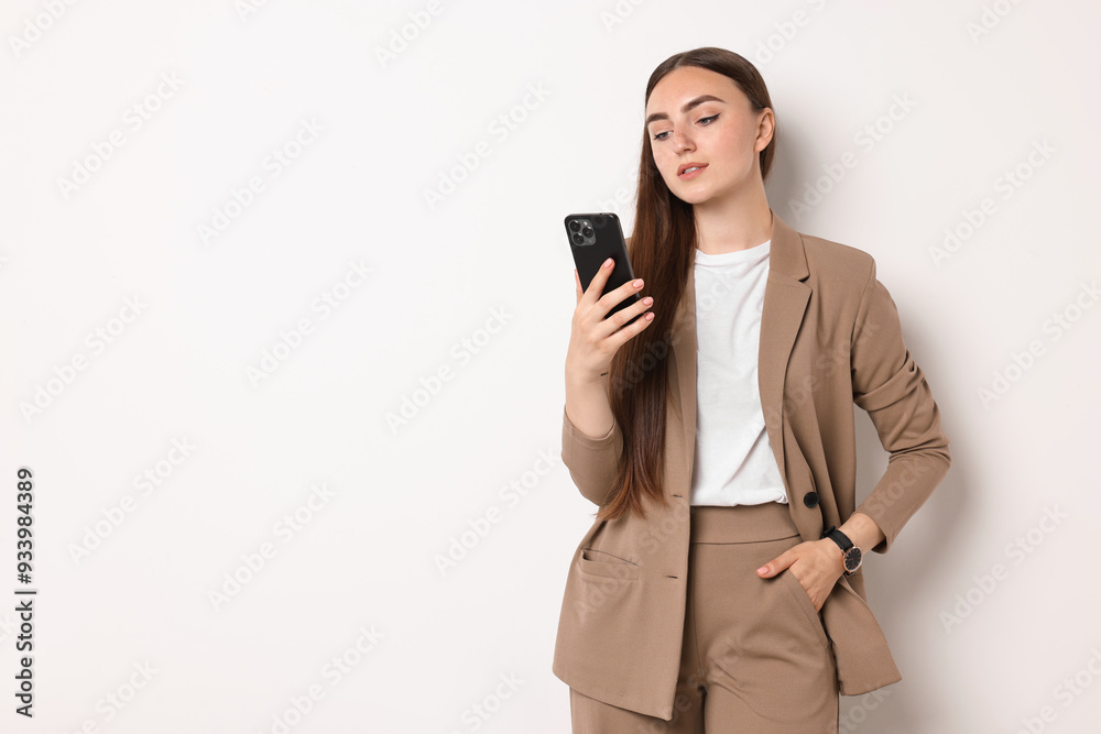 Woman in beige suit using smartphone on white background, space for text Woman in beige suit using smartphone on white background, space for text
