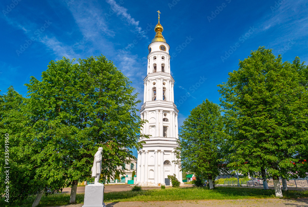 The bell tower of the Holy Trinity Church and a monument of Alexander Pushkin in a small Russian town of Lezhnevo
