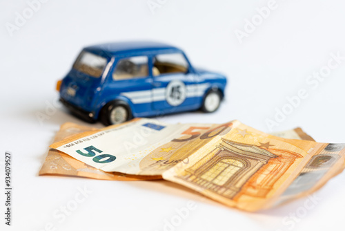 Toy car and banknotes. Rising prices for old cars in Ukraine