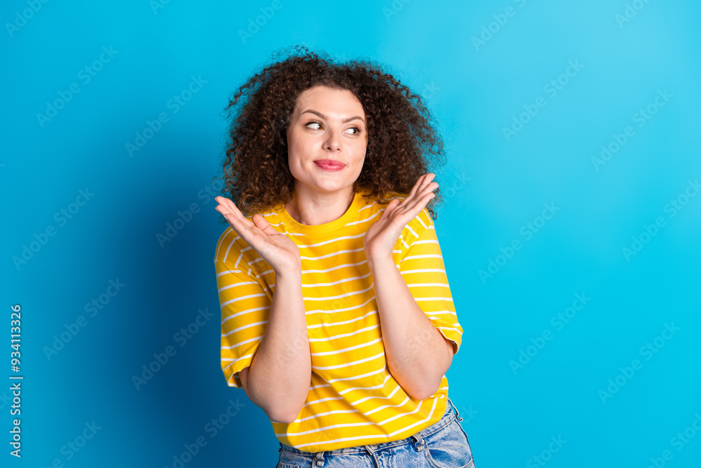 Photo portrait of pretty young girl raise hands look empty space wear trendy striped yellow outfit isolated on blue color background Photo portrait of pretty young girl raise hands look empty space wear trendy striped yellow outfit isolated on blue color background