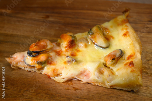 piece of pizza with seafood - mussels, shrimp, squid rin photo