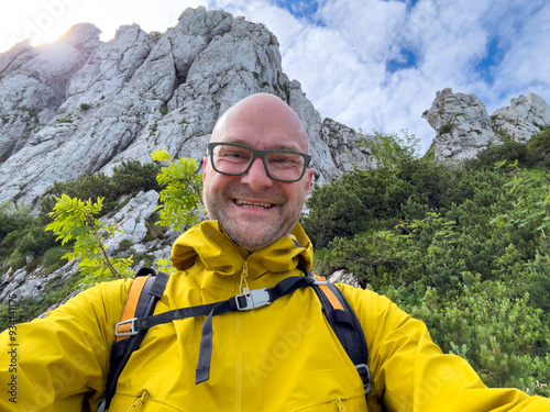 Man in yellow jacket hike at Bavarian nature with the mountains at the background photo