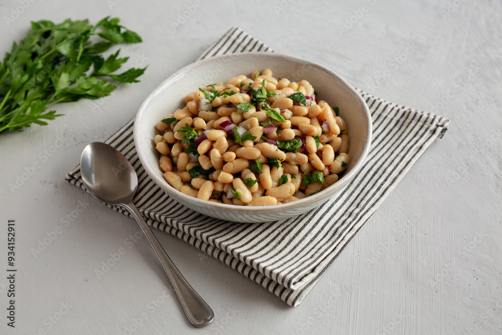 Homemade White Bean Salad with Herbs and Onion in a Bowl, side view. Homemade White Bean Salad with Herbs and Onion in a Bowl, side view.
