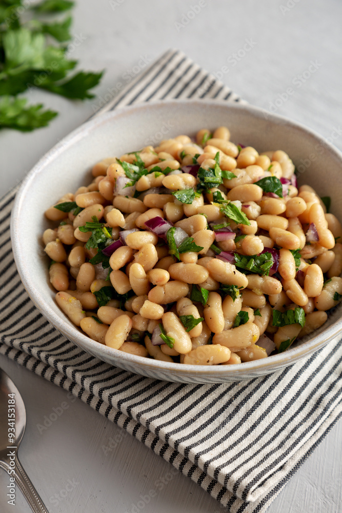 Homemade White Bean Salad with Herbs and Onion in a Bowl, side view. Homemade White Bean Salad with Herbs and Onion in a Bowl, side view.