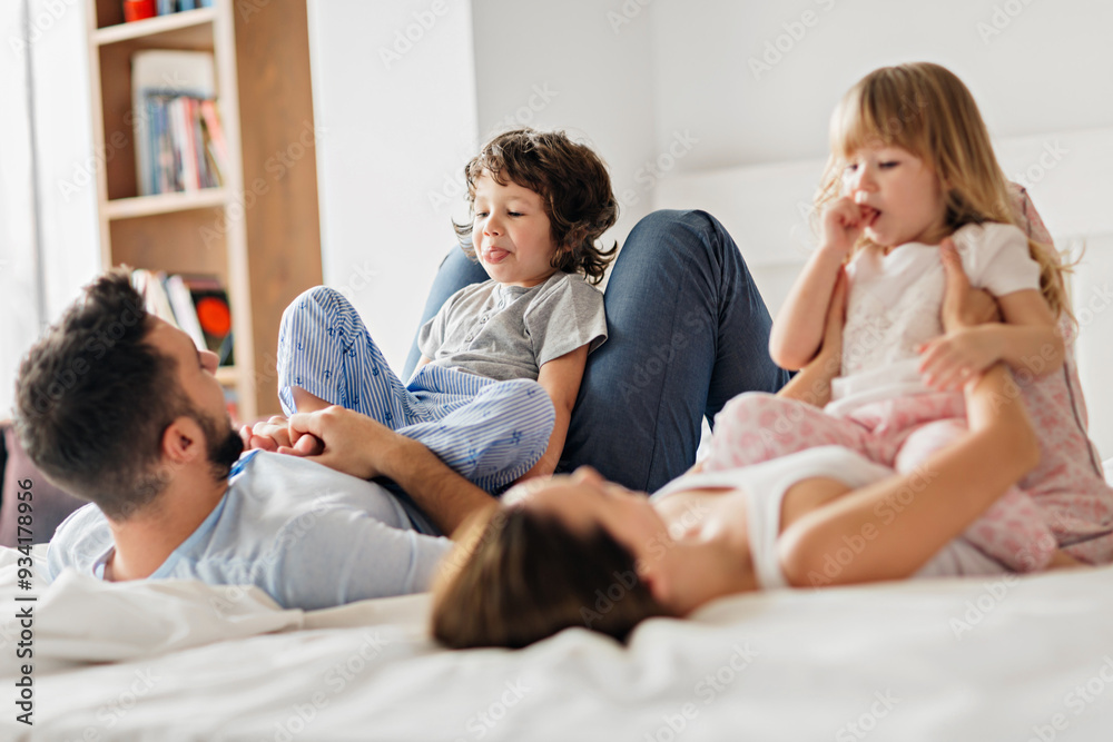 Happy family playing and laughing together on bed in the morning Happy family playing and laughing together on bed in the morning