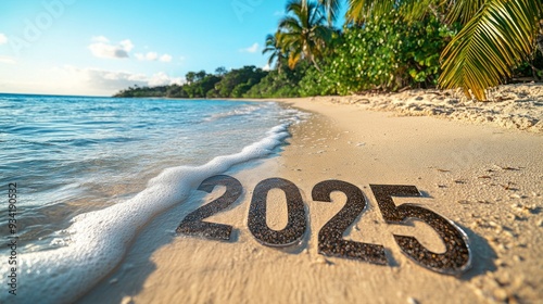 Gentle waves lap at the shore, revealing the year 2025 written in the warm golden sand, framed by vibrant tropical foliage under a clear blue sky