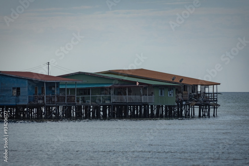 Fishing village houses over the water garbage poor areas in Sabah province in Malaysia photo