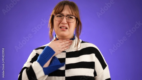 Portrait of young woman 20s sick with cough and sore throat isolated on purple background in studio with copy space photo